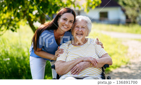 Home nurse taking care of elderly woman in wheelchair. 136891700