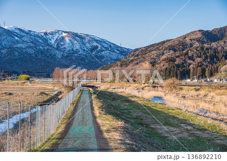 知内川沿いのサイクリングロードと残雪の野坂山地　滋賀県高島市マキノ町 136892210
