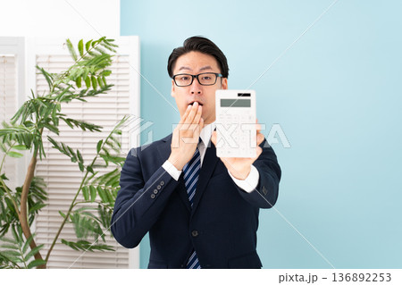 計算機を持ち驚く男性 136892253