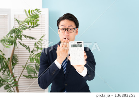 計算機を持ち驚く男性 136892255