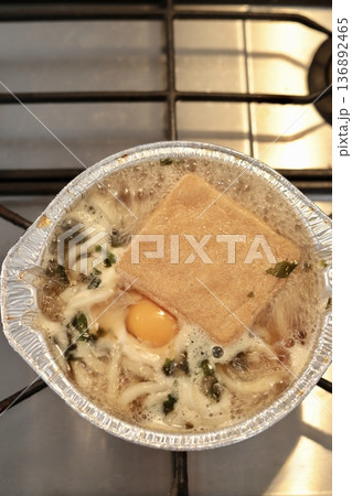 アルミ鍋の鍋焼きうどんを火にかけて煮立たせているところ 136892465