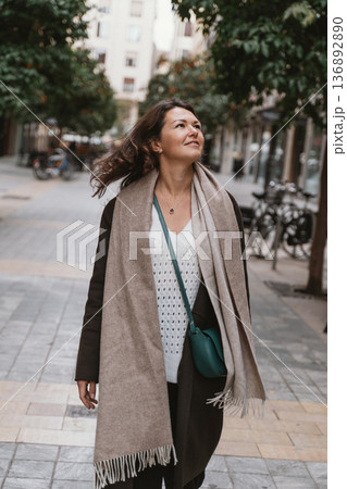 Woman Enjoying a Stroll on a City Street 136892890
