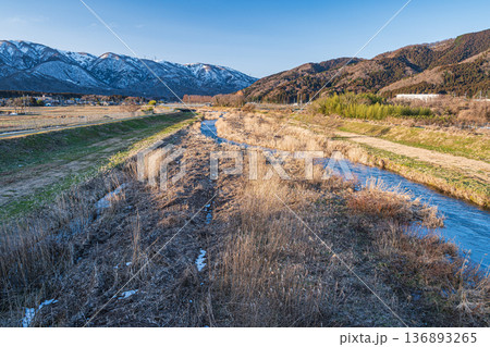 浅春の知内川と残雪の野坂山地　滋賀県高島市マキノ町 136893265
