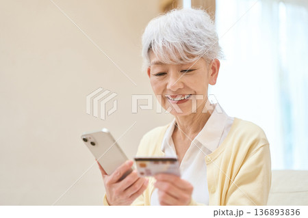 マイナンバーカードとスマホを連携するシニア女性 マイナンバーカードとスマホを連携するシニア女性 136893836