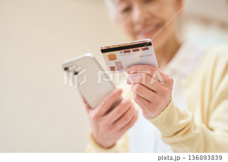 マイナンバーカードとスマホを連携するシニア女性 136893839