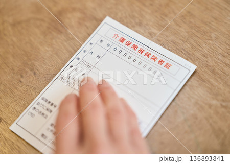 介護保険被保険者証を持つシニア女性の手元 介護保険被保険者証を持つシニア女性の手元 136893841