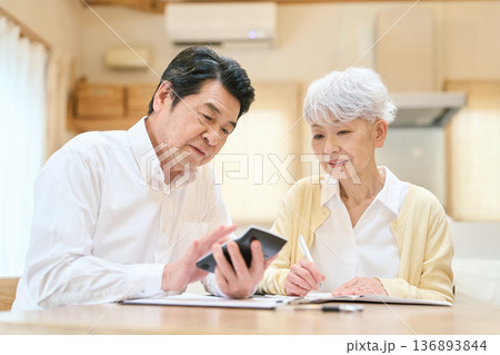 家計の計算をするアジア人シニア夫婦 136893844