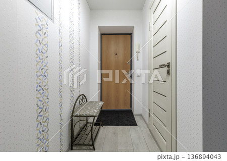 Cozy Apartment Entryway with Wooden Door and Patterned Wallpaper Cozy Apartment Entryway with Wooden Door and Patterned Wallpaper 136894043