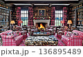 Cozy library interior with fireplace, floral armchairs, and port 136895489