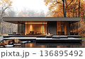 Modern Glass House in Autumnal Forest with Reflective Water and 136895492
