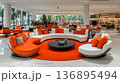 Modern Hotel Lobby with Circular Seating and Vibrant Orange Acce 136895494