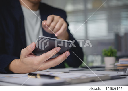 Businessman hand use calculator calculate data. Financial accounting concept. Man work office desk, planning budget, analyze report document. Investment savings economy tax calculation, data analysis. 136895654