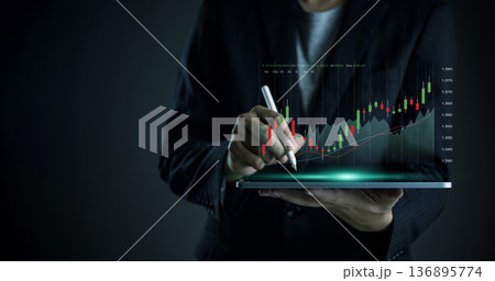 Businessman hand use tablet stylus pen trading stock market. Virtual candlestick chart graph uptrend. Financial investment technology, business growth concept. Digital data analysis, success strategy. Businessman hand use tablet stylus pen trading stock market. Virtual candlestick chart graph uptrend. Financial investment technology, business growth concept. Digital data analysis, success strategy. 136895774