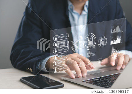 Businessman analyzing employee performance on HR management software dashboard. Reviewing digital CVs, personnel data for corporate development. Technology for modern recruitment strategy. 136896517
