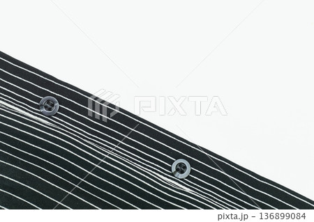 Two buttons on part of a black white linear down shirt Two buttons on part of a black white linear down shirt 136899084