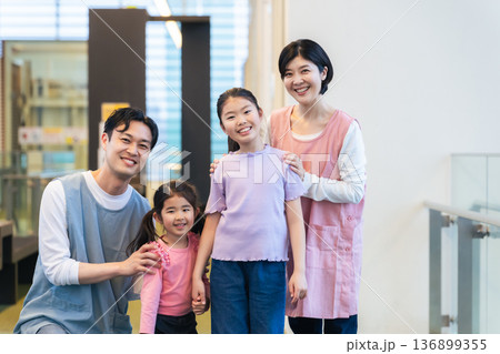 施設の中で並ぶ女の子と保育士 施設の中で並ぶ女の子と保育士 136899355