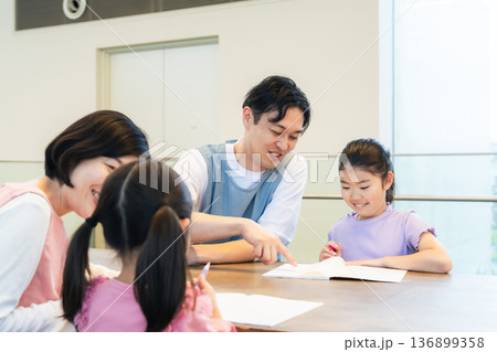 勉強する子供たちと見守るケアスタッフ 136899358