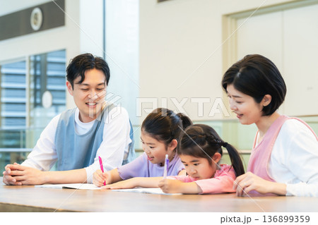 勉強する子供たちと見守るケアスタッフ 勉強する子供たちと見守るケアスタッフ 136899359
