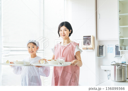 白衣を着て食事を運ぶ女の子と女性 136899366