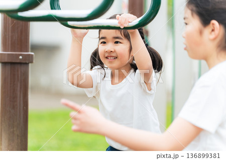 公園の雲梯で遊ぶ女の子 公園の雲梯で遊ぶ女の子 136899381