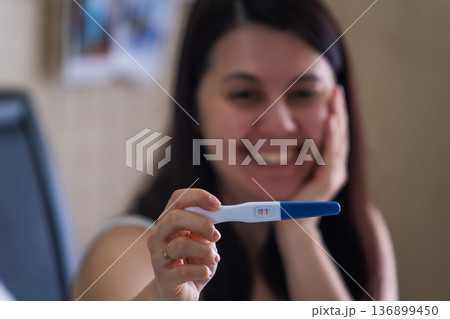 Surprised Woman with Positive Pregnancy Test Surprised Woman with Positive Pregnancy Test 136899450