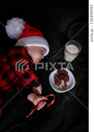 Sleeping Baby in Santa Hat with Cookies and Milk 136899485