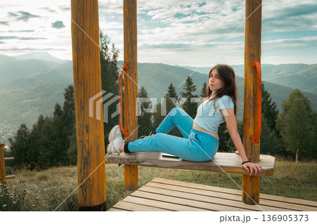 Young Woman Relaxing at Mountain Viewpoint 136905373
