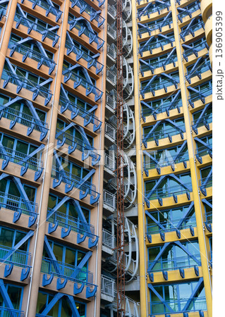 The facade of a modern office building with blue and yellow metal structures 136905399