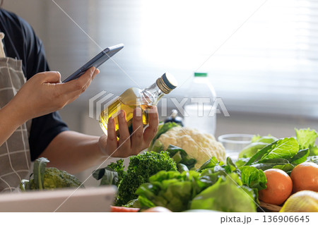 Middle Aged Asian Man Checking Olive Oil for Healthy Aging Diet 136906645