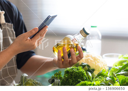 Middle Aged Asian Man Checking Olive Oil for Healthy Aging Diet Middle Aged Asian Man Checking Olive Oil for Healthy Aging Diet 136906650