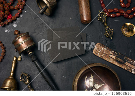 Blank black business cards in the center surrounded by a Tibetan singing bowl, prayer drum, bells, rosary beads and ritual objects Blank black business cards in the center surrounded by a Tibetan singing bowl, prayer drum, bells, rosary beads and ritual objects 136908616