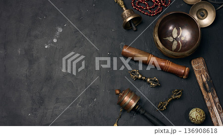 A Tibetan singing bowl, wooden resonator, ritual vajras, bell, prayer wheel, rosary beads, and incense A Tibetan singing bowl, wooden resonator, ritual vajras, bell, prayer wheel, rosary beads, and incense 136908618