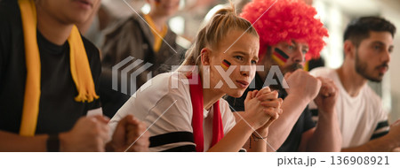 Worried football fans supproting German national team in soccer match at stadium. Worried football fans supproting German national team in soccer match at stadium. 136908921