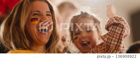 Excited football fans, supporting German national team in live soccer match at stadium. Excited football fans, supporting German national team in live soccer match at stadium. 136908922