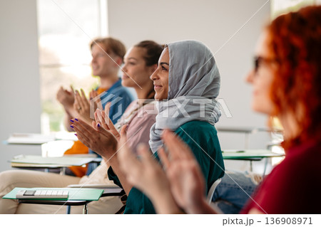 Group of college students attending lecture in university hall. Group of college students attending lecture in university hall. 136908971