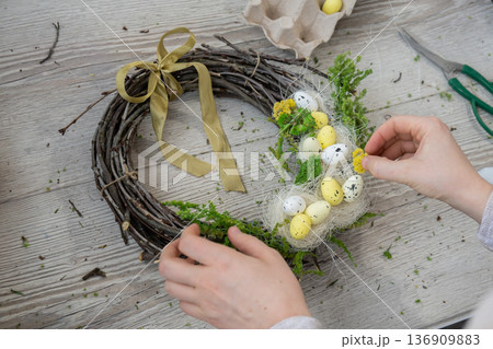 Handmade Easter wreath festive yellow egg decorations. Traditional holiday preparation craft master class of creative making decor. Hands-on activities sustainable responsible holiday gift workshop Handmade Easter wreath festive yellow egg decorations. Traditional holiday preparation craft master class of creative making decor. Hands-on activities sustainable responsible holiday gift workshop 136909883