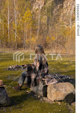 Beautiful blonde girl playing acoustic guitar and singing relaxing enjoying outdoors on sunny autumn day. Hippie woman in boho style learning and practicing playing musical instrument. Fall leaves Beautiful blonde girl playing acoustic guitar and singing relaxing enjoying outdoors on sunny autumn day. Hippie woman in boho style learning and practicing playing musical instrument. Fall leaves 136909982
