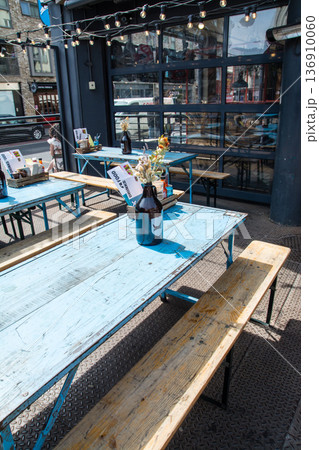 レストランの店先に置かれた木製の長椅子と長いテーブル　ロンドン東のショーディッチの街並み 136910060