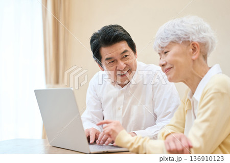 リビングでPCを使うアジア人シニア夫婦 リビングでPCを使うアジア人シニア夫婦 136910123