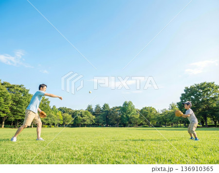公園でキャッチボールをする父親と息子 136910365