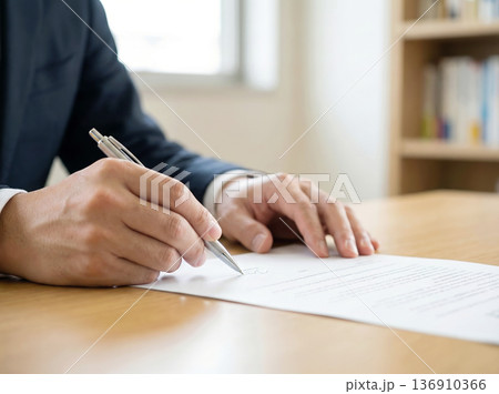 契約書にサインする男性　顔無し 136910366