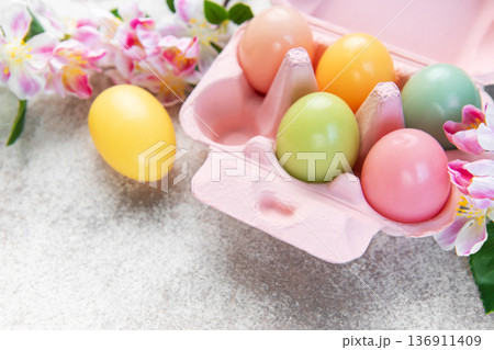 Colorful easter eggs in carton with spring flowers Colorful easter eggs in carton with spring flowers 136911409