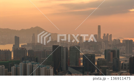 Hazy Kowloon skyline glowing under warm sunset Feb 19 2026 136911475