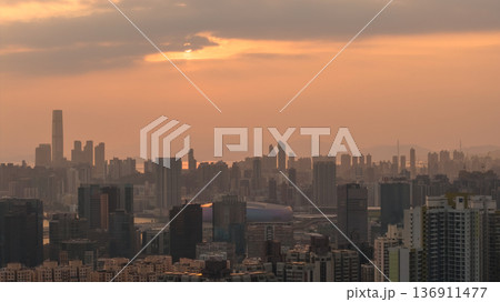 Hazy Kowloon skyline glowing under warm sunset Feb 19 2026 136911477