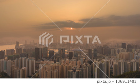 Hazy Kowloon skyline glowing under warm sunset Feb 19 2026 Hazy Kowloon skyline glowing under warm sunset Feb 19 2026 136911483