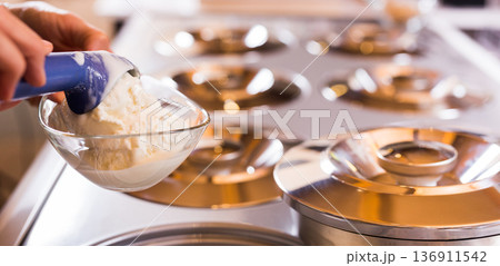 Ball of vanilla ice cream in ice cream razor in cafe 136911542