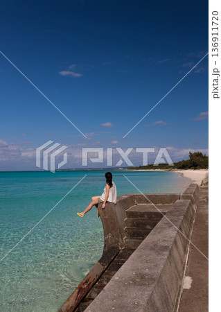 晴れた日に透明なターコイズブルーの海を眺める女性の後ろ姿 晴れた日に透明なターコイズブルーの海を眺める女性の後ろ姿 136911720