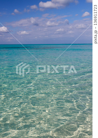 青空と雲の下に広がる透明なターコイズブルーの海 136911723