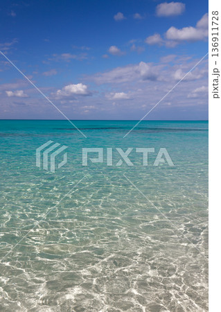 青空と雲の下に広がる透明なターコイズブルーの海 136911728