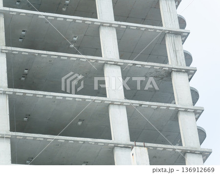 Concrete frame of a building column with floor slabs during construction. Modern architecture development for urban project. Concrete frame of a building column with floor slabs during construction. Modern architecture development for urban project. 136912669